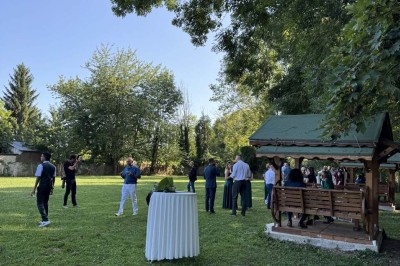 Table élégamment dressée avec vaisselle raffinée, centre de table floral et décoration lumineuse en arrière-plan.