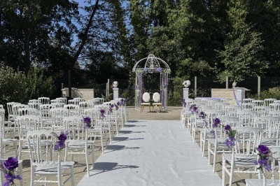 Table élégamment dressée avec vaisselle raffinée, centre de table floral et décoration lumineuse en arrière-plan.