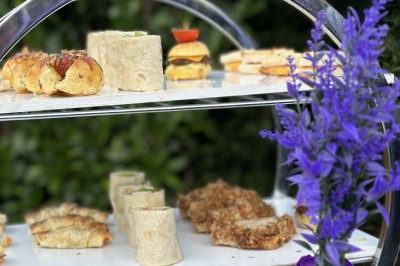 Table élégamment dressée avec vaisselle raffinée, centre de table floral et décoration lumineuse en arrière-plan.