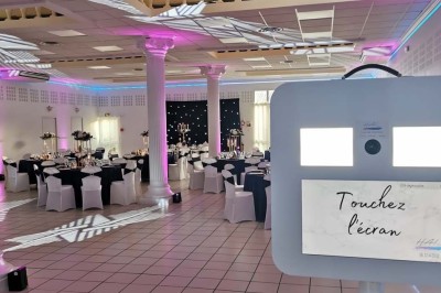 Table élégamment dressée avec vaisselle raffinée, centre de table floral et décoration lumineuse en arrière-plan.