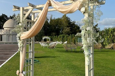 Table élégamment dressée avec vaisselle raffinée, centre de table floral et décoration lumineuse en arrière-plan.