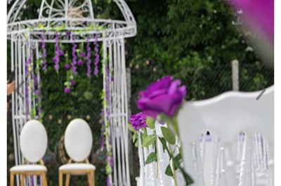 Table élégamment dressée avec vaisselle raffinée, centre de table floral et décoration lumineuse en arrière-plan.