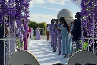 Table élégamment dressée avec vaisselle raffinée, centre de table floral et décoration lumineuse en arrière-plan.