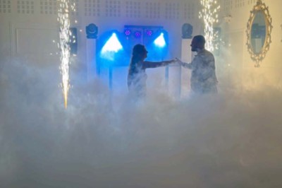 Table élégamment dressée avec vaisselle raffinée, centre de table floral et décoration lumineuse en arrière-plan.