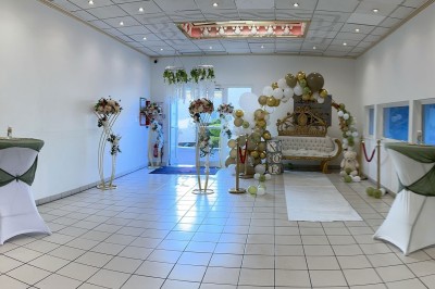 Table élégamment dressée avec vaisselle raffinée, centre de table floral et décoration lumineuse en arrière-plan.