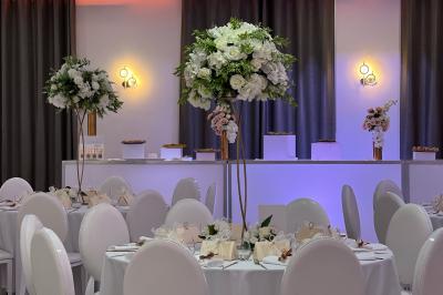 Dessert pyramidal en fromage blanc accompagné de fraises tranchées et d'une fleur comestible sur une assiette blanche.