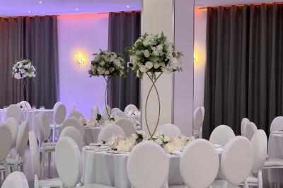 Dessert pyramidal en fromage blanc accompagné de fraises tranchées et d'une fleur comestible sur une assiette blanche.