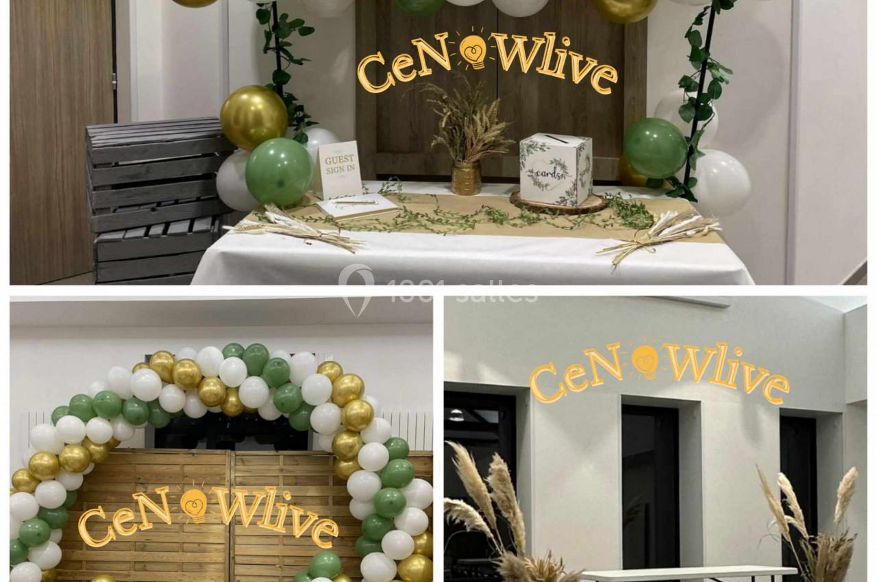 Décoration avec ballons blancs, verts et dorés, table ornée de végétaux et arche en bois dans un espace intérieur.