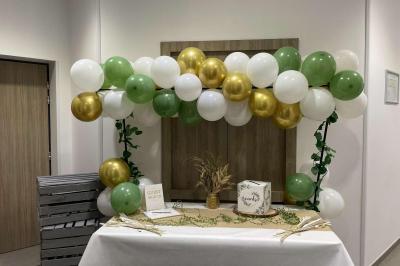 Deux femmes regardent un écran d'une borne photo rétro dans un espace décoré pour la Saint-Patrick.