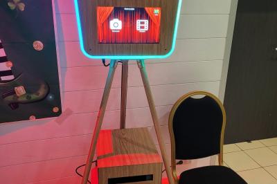 Deux femmes regardent un écran d'une borne photo rétro dans un espace décoré pour la Saint-Patrick.