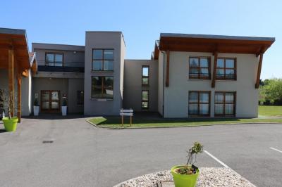 Salle de restaurant lumineuse avec tables dressées, nappes blanches, chaises noires et grandes fenêtres donnant sur l…