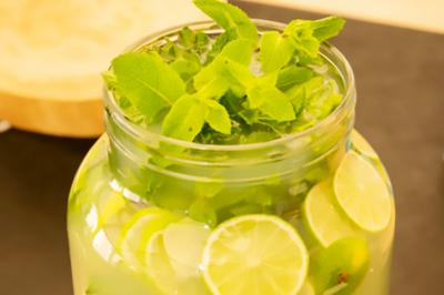 Des personnes préparent et disposent des desserts sur des assiettes alignées dans une cuisine professionnelle.