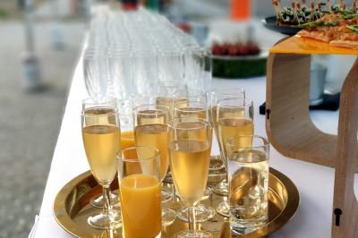 Des personnes préparent et disposent des desserts sur des assiettes alignées dans une cuisine professionnelle.