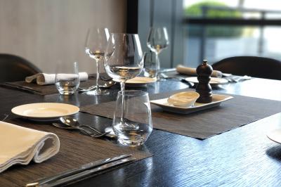 Des personnes préparent et disposent des desserts sur des assiettes alignées dans une cuisine professionnelle.