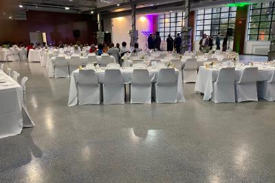 Des personnes préparent et disposent des desserts sur des assiettes alignées dans une cuisine professionnelle.