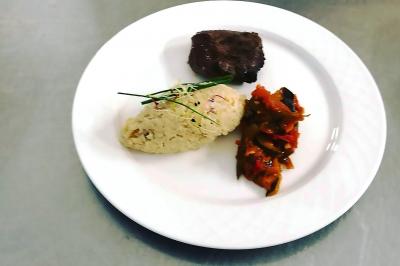 Des personnes préparent et disposent des desserts sur des assiettes alignées dans une cuisine professionnelle.