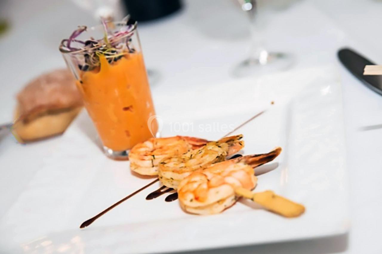 Brochette de crevettes grillées avec filet de sauce balsamique, accompagnée d'un verre de velouté orange.
