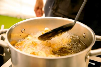 Des personnes préparent et dressent des assiettes avec des desserts dans une cuisine professionnelle.