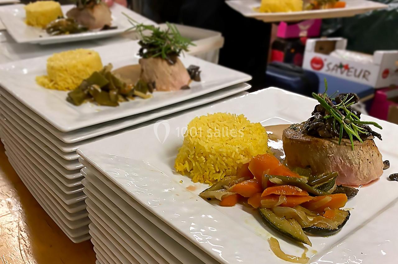 Assiettes dressées avec filet de viande, riz safrané, légumes sautés et haricots verts, prêtes à être servies.
