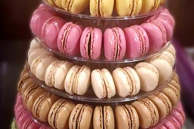 Des personnes préparent et dressent des assiettes avec des desserts dans une cuisine professionnelle.