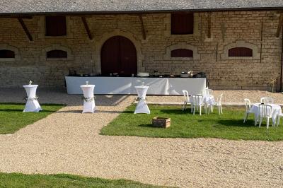 Des personnes préparent et dressent des assiettes avec des desserts dans une cuisine professionnelle.