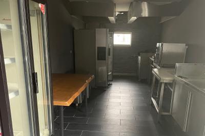 Vue d'un espace extérieur avec pelouse, structures gonflables colorées et arbres en arrière-plan, sous un ciel bleu.