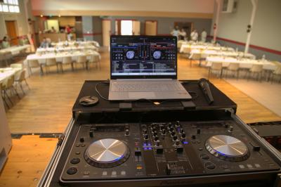 Table de mixage professionnelle avec plusieurs platines, écrans et commandes, sur fond bleu dégradé.