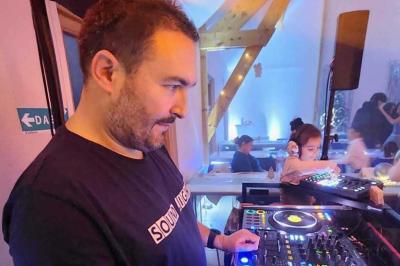 Table de mixage professionnelle avec plusieurs platines, écrans et commandes, sur fond bleu dégradé.