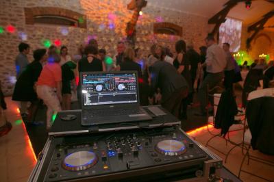 Table de mixage DJ professionnelle avec plusieurs platines, écrans et un QR code visible en arrière-plan.