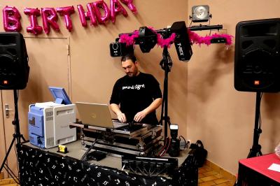 Table de mixage DJ professionnelle avec plusieurs platines, écrans et un QR code visible en arrière-plan.