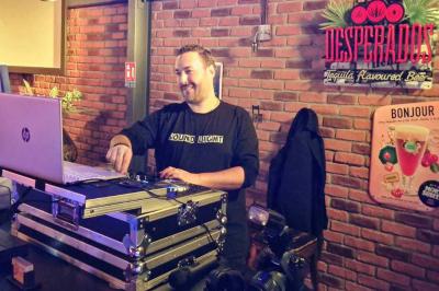 Table de mixage DJ professionnelle avec plusieurs platines, écrans et un QR code visible en arrière-plan.