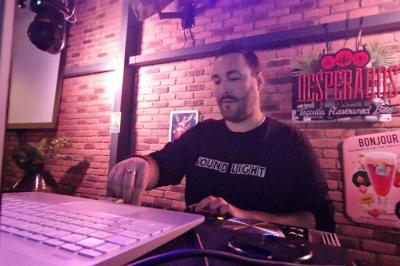 Table de mixage DJ professionnelle avec plusieurs platines, écrans et un QR code visible en arrière-plan.