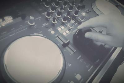 Table de mixage DJ professionnelle avec plusieurs platines, écrans et un QR code visible en arrière-plan.