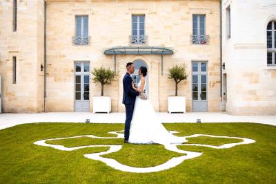 Vue d'un arbre à travers une fenêtre cintrée, encadrée par un intérieur lumineux avec un luminaire suspendu.