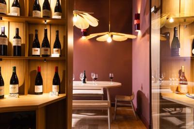 Salle de restaurant lumineuse avec tables en bois, banquettes rembourrées et décor mural en bois.