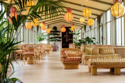 Salle de restaurant lumineuse avec tables en bois, banquettes rembourrées et décor mural en bois.