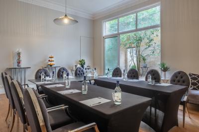 Salle de massage avec table recouverte de serviettes, éclairage tamisé et bougies pour une ambiance relaxante.