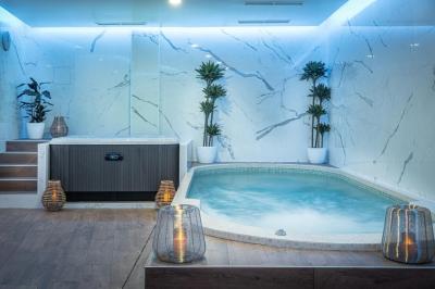 Salle de massage avec table recouverte de serviettes, éclairage tamisé et bougies pour une ambiance relaxante.