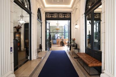 Salle à manger moderne avec table ronde, chaises violettes, parquet en chevrons, étagères et coin café.