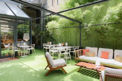Salle à manger moderne avec table ronde, chaises violettes, parquet en chevrons, étagères et coin café.