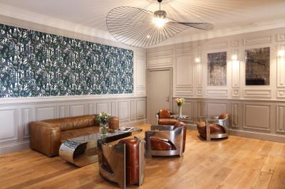 Salle à manger moderne avec table ronde, chaises violettes, parquet en chevrons, étagères et coin café.