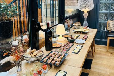 Salle à manger moderne avec table ronde, chaises violettes, parquet en chevrons, étagères et coin café.
