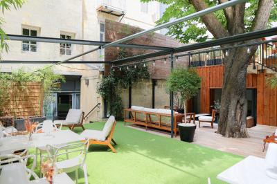 Salle à manger moderne avec table ronde, chaises violettes, parquet en chevrons, étagères et coin café.