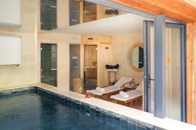 Salle à manger moderne avec table ronde, chaises violettes, parquet en chevrons, étagères et coin café.