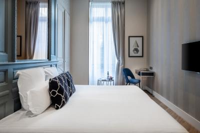 Salle à manger moderne avec table ronde, chaises violettes, parquet en chevrons, étagères et coin café.