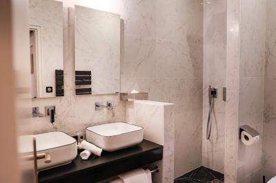 Salle à manger moderne avec table ronde, chaises violettes, parquet en chevrons, étagères et coin café.