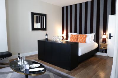 Salle à manger moderne avec table ronde, chaises violettes, parquet en chevrons, étagères et coin café.