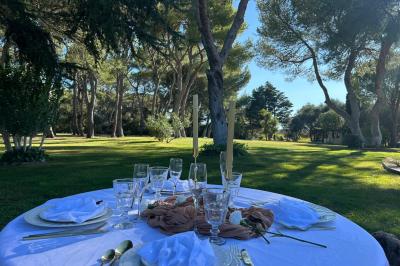 Grand chapiteau beige éclairé par des guirlandes lumineuses, abritant des tables rondes dressées pour un événement en plein…