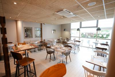 Plateau avec jus d'orange, verres, morceaux de fruits et viennoiseries sur une étagère, devant des photos murales.