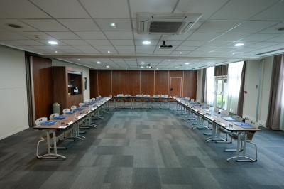 Plateau avec jus d'orange, verres, morceaux de fruits et viennoiseries sur une étagère, devant des photos murales.